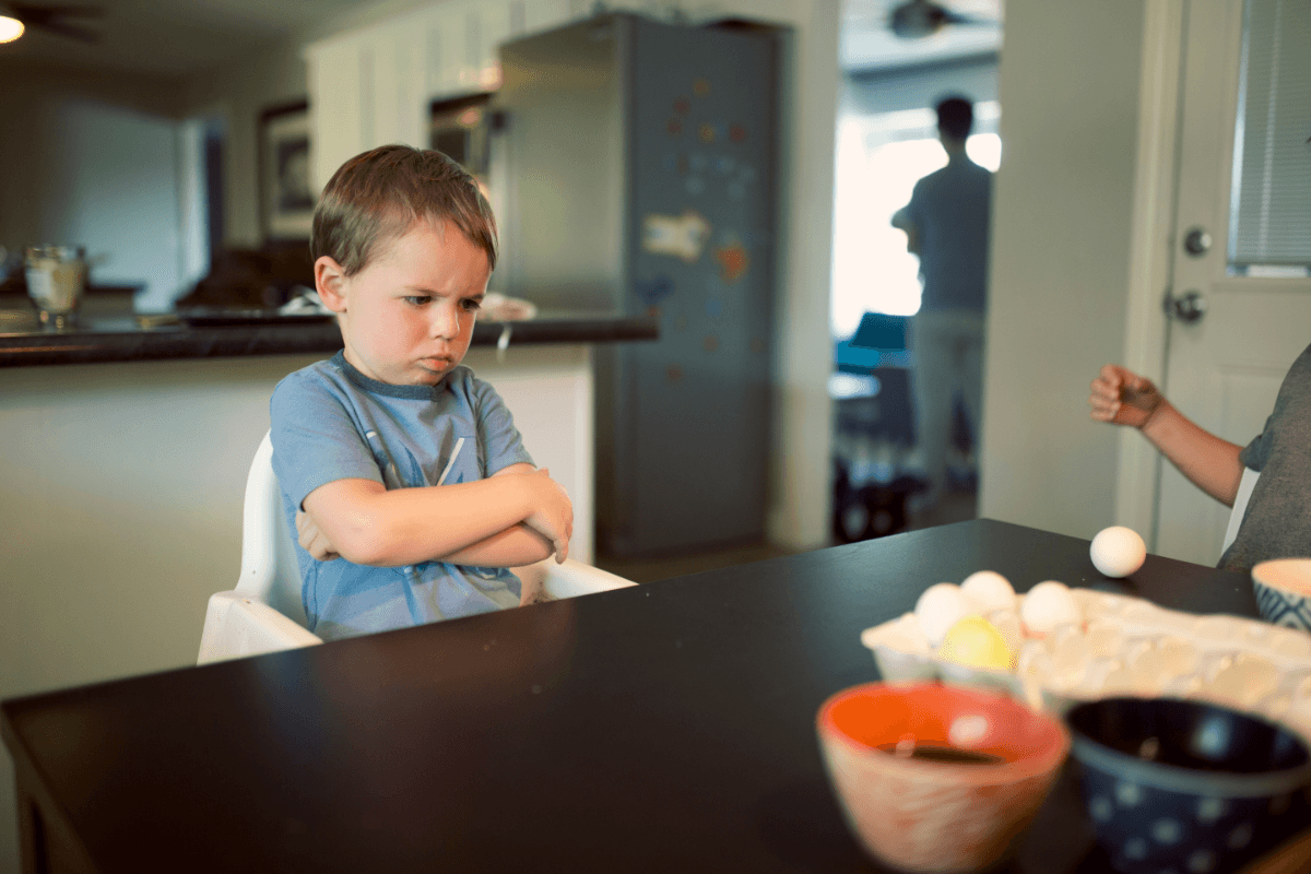 Angry young boy sitting on chair