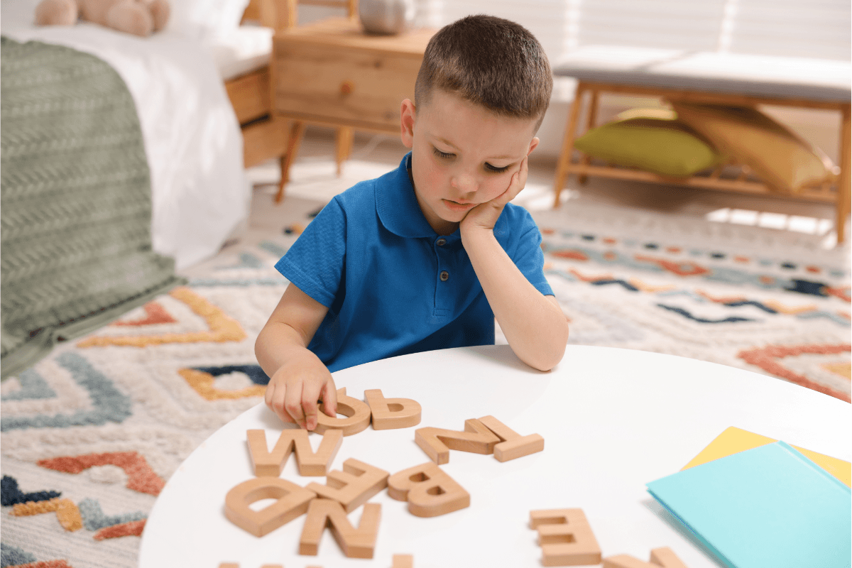 Boy playing with letters on table